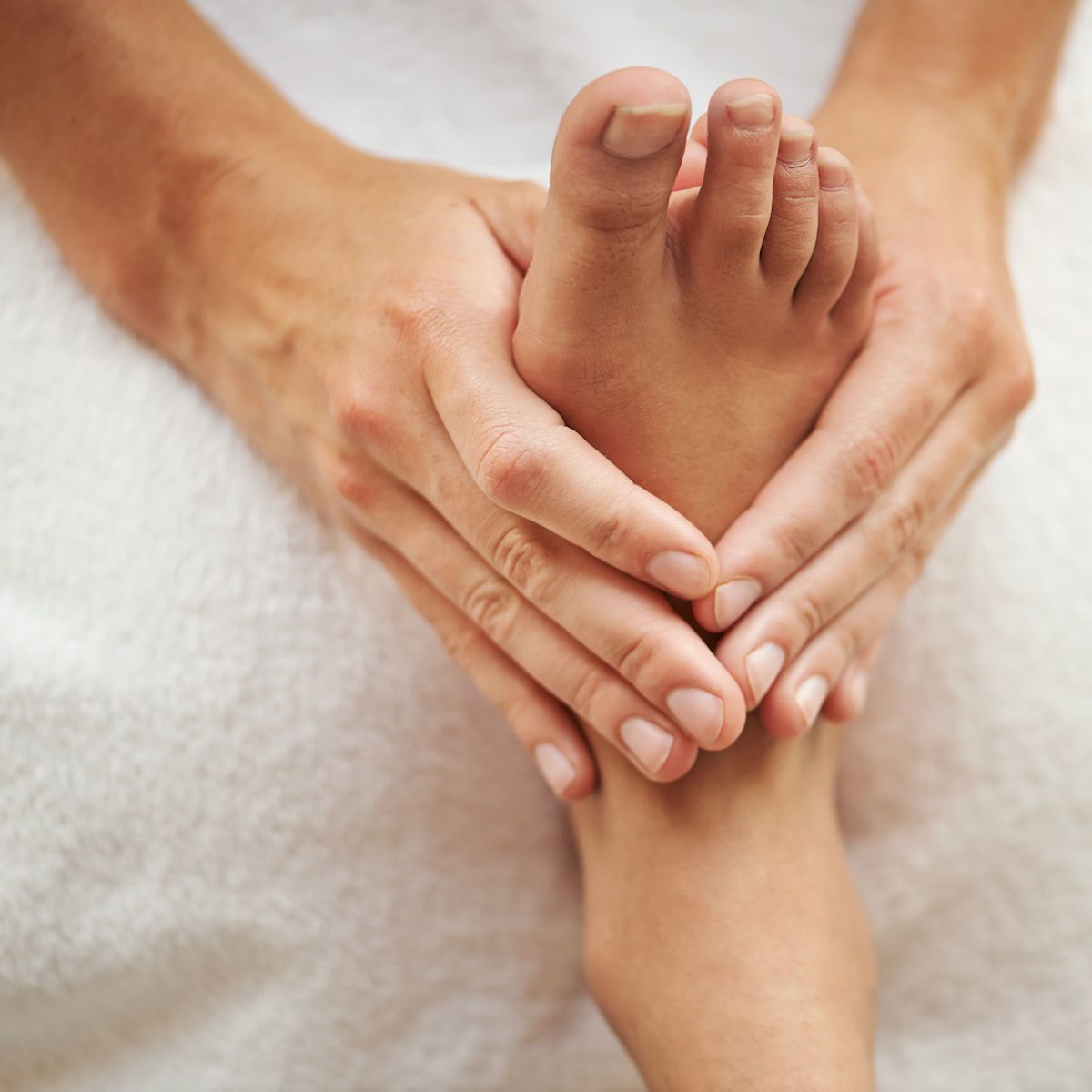Séance de réflexologie plantaire, pieds travaillés sur une table de soin